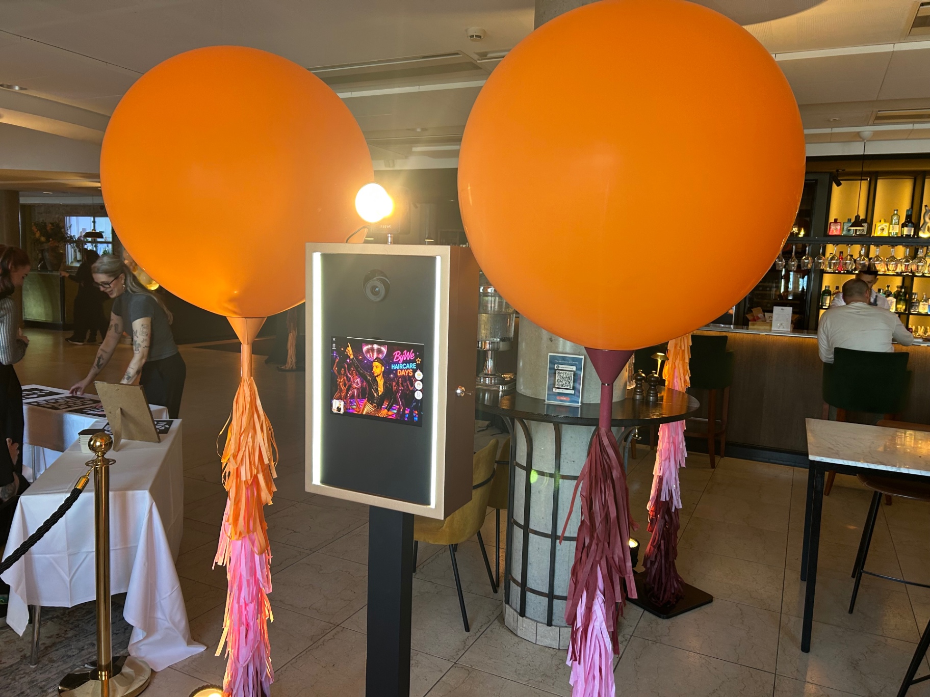 El fotomatón de Costa Photo Booth entre globos naranjas en un evento